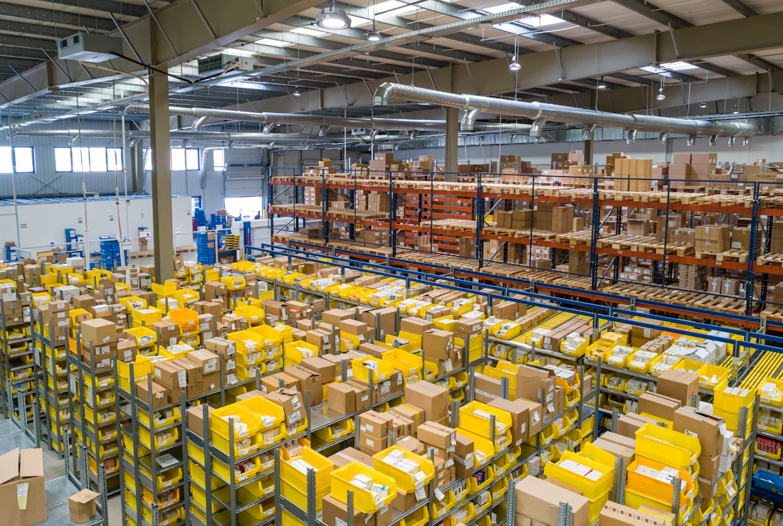 Überblick über eine Lagerhalle mit kommissionierter Ware auf Paletten und Regalflächen